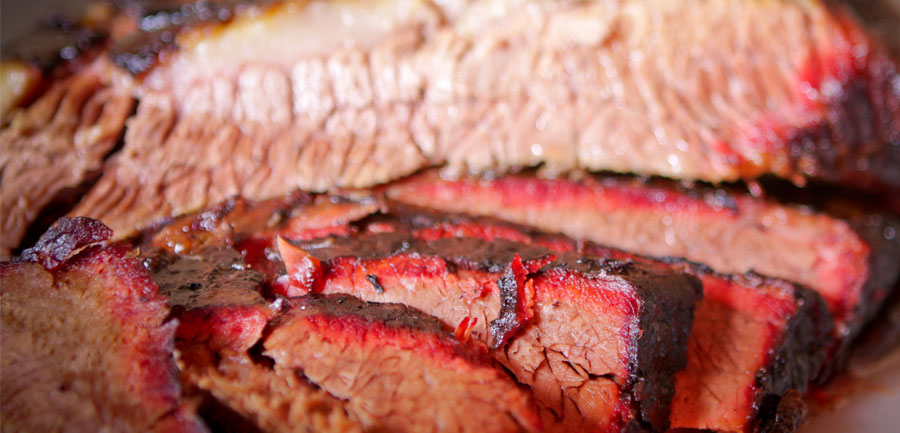 Slices of smoked beef brisket with a deep red smoke ring
